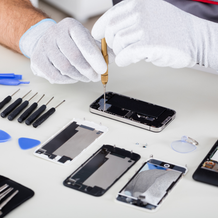 Professional smartphone repair showing hands in white gloves using precision tools on disassembled phone components with repair tools laid out on white surface